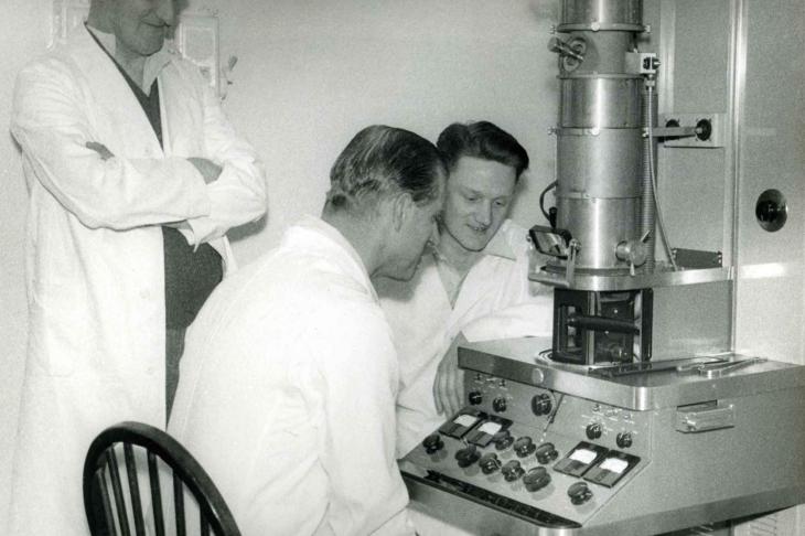 Prince Philip sits at early transmission electron microscope at Pirbright in 1956