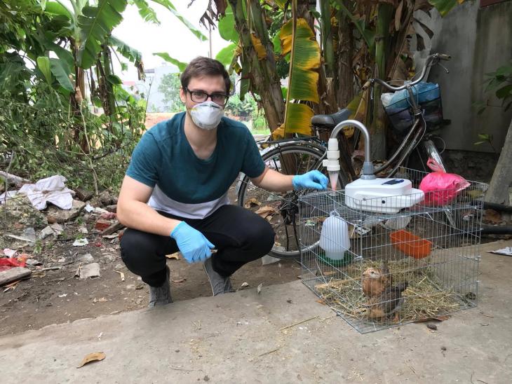 Joshua Sealy air sampling chickens for avian flu in Vietnam