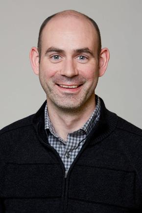 Dr Trevor Sweeney, group leader, Viral Gene Expression, The Pirbright Institute Dr Trevor Sweeney, smiling. Head and shoulders image of Trevor in a grey checked shirt with a black jumper over it.